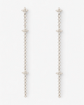 Pair of long, thin earrings with star-like ends on a white background