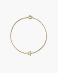 Gold bracelet with a small arrow charm on a white background