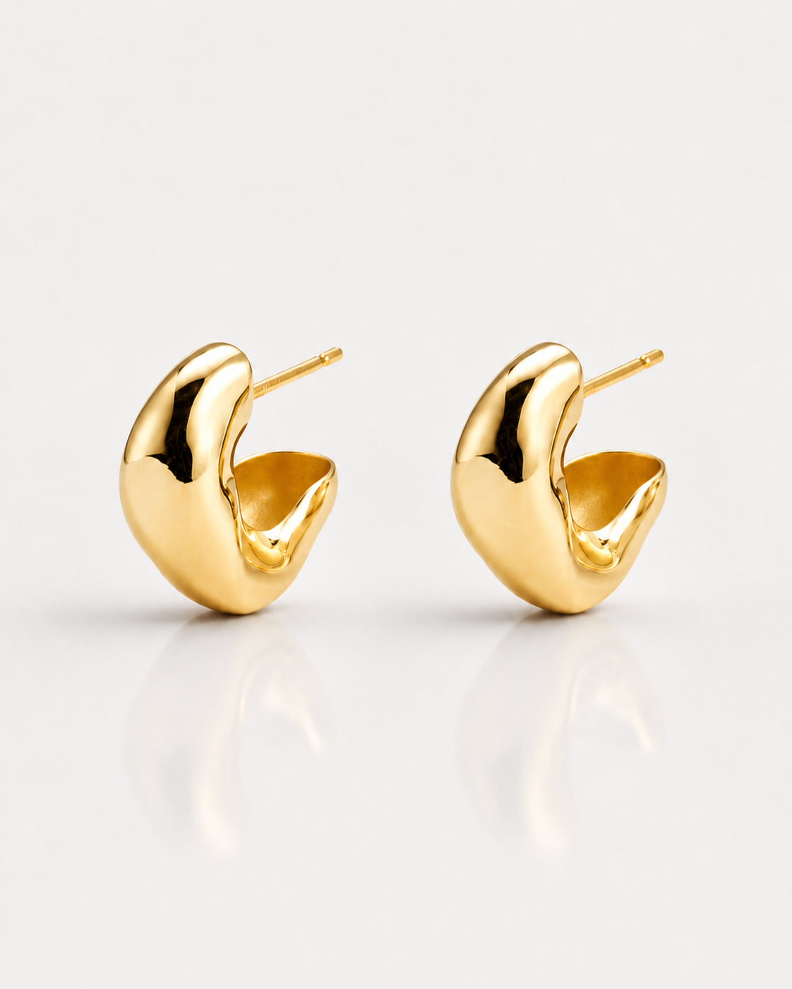 Gold hoop earrings on a light gray background