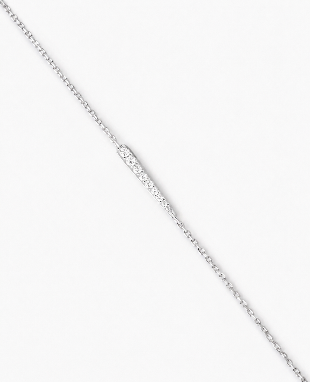 Silver chain necklace on a light gray background