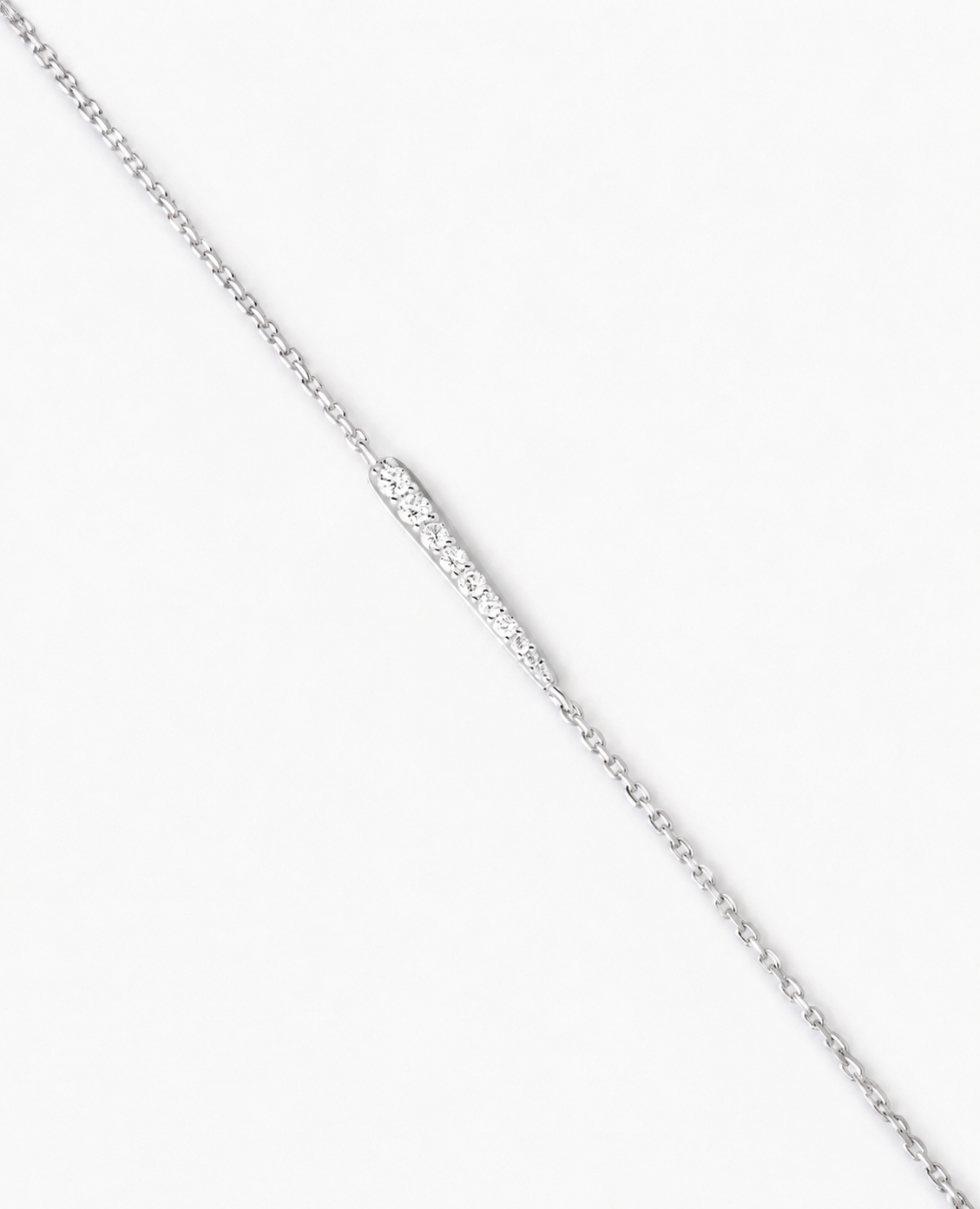 Silver chain necklace on a light gray background