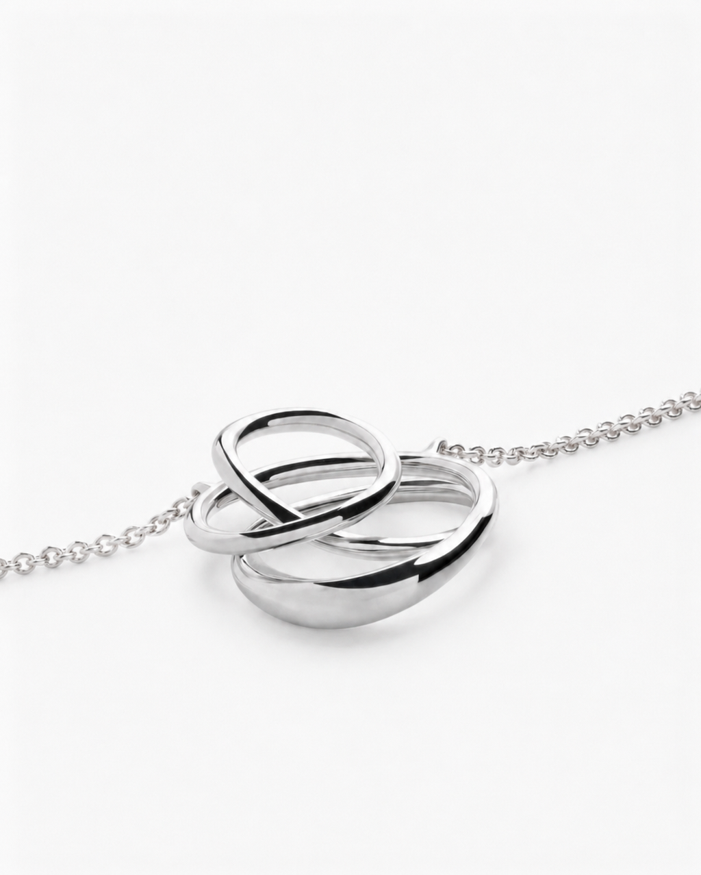 Silver interlocking ring necklace on a white background