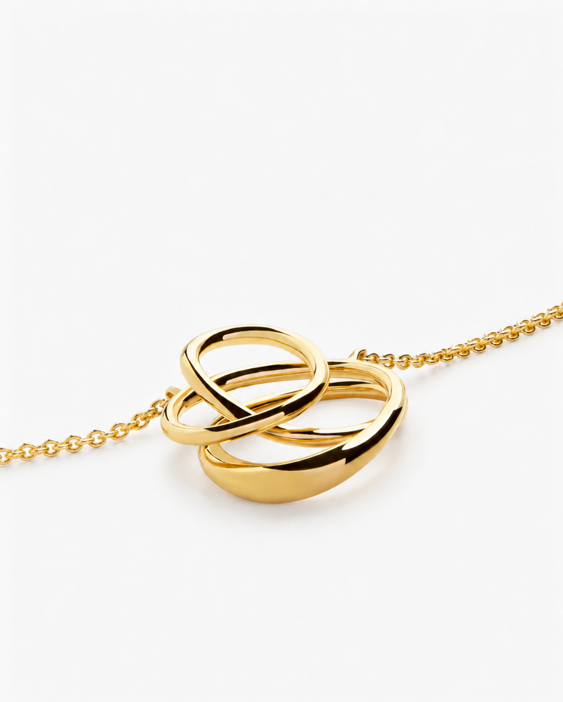 Gold necklace with interlocking rings on a white background
